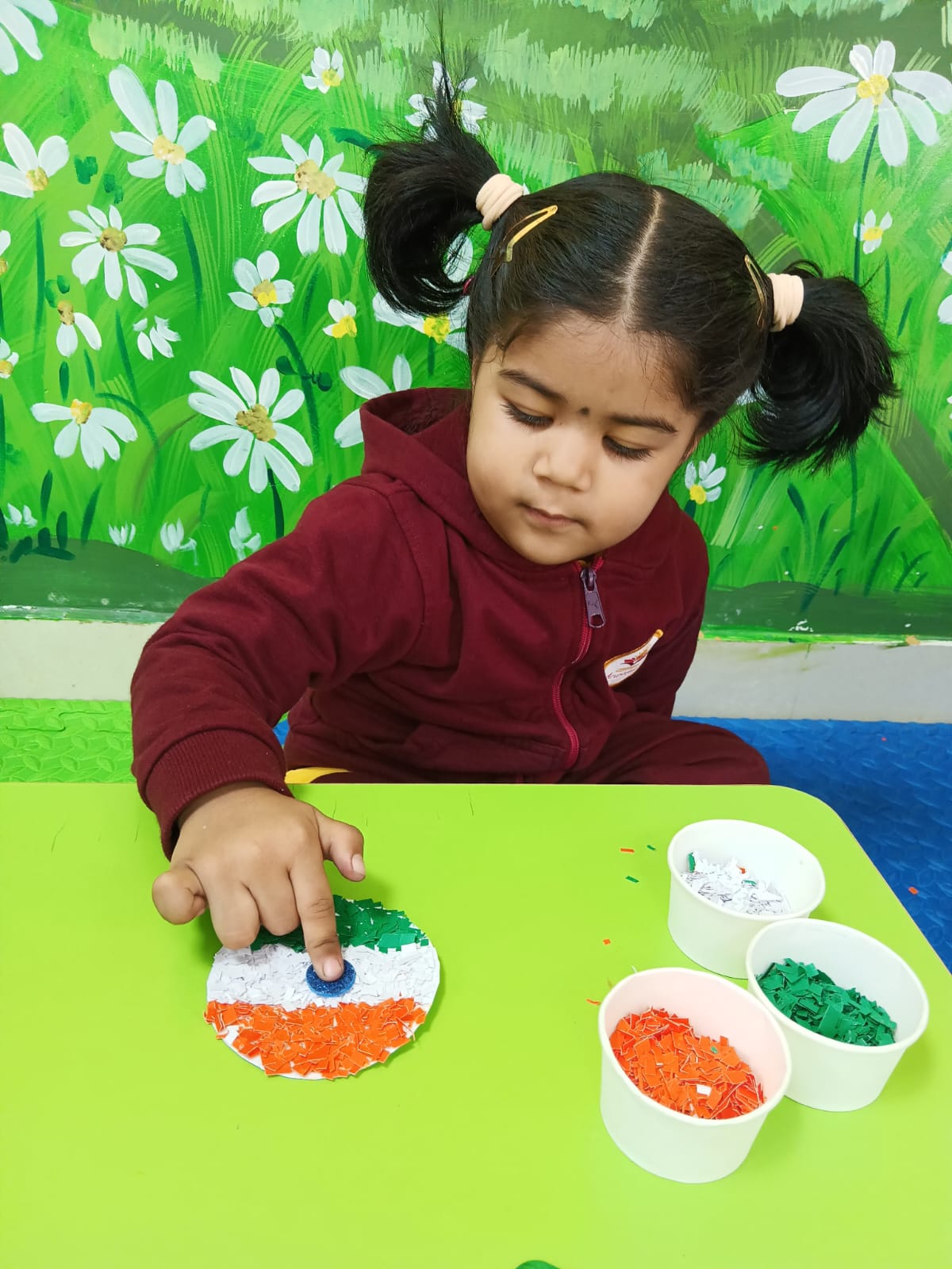 A young child creating a tricolour flag mosaic craft
