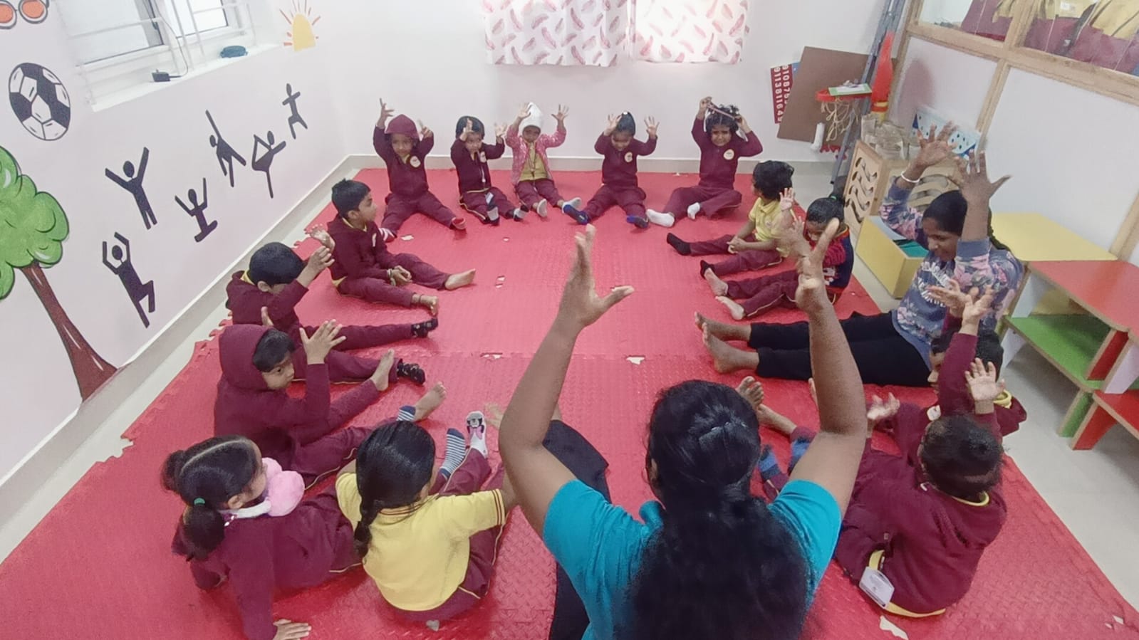 Children practising yoga and movement in a circle with their educator